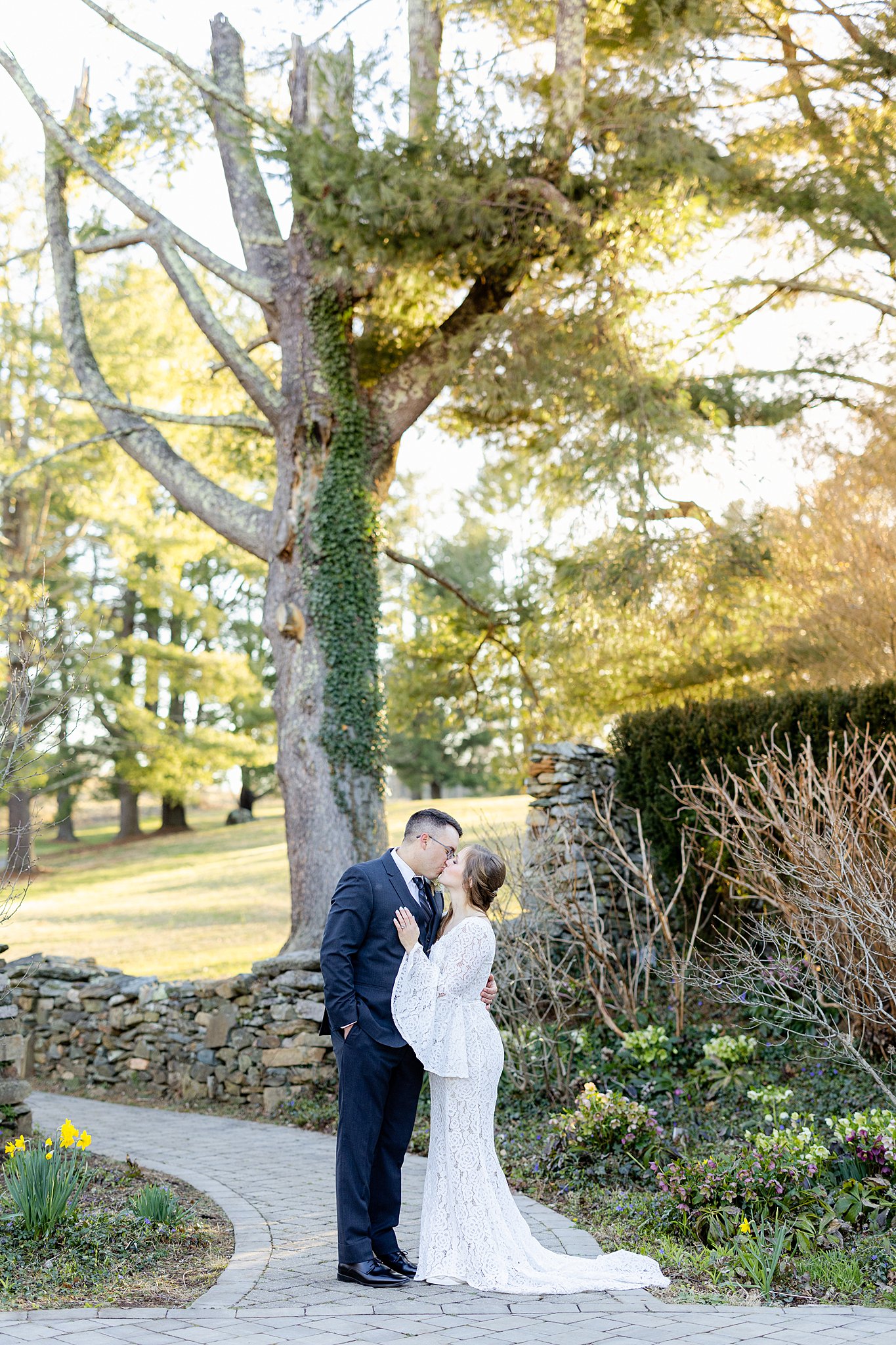 Newlyweds kiss in a stone path of a groomed garden virginia elopement