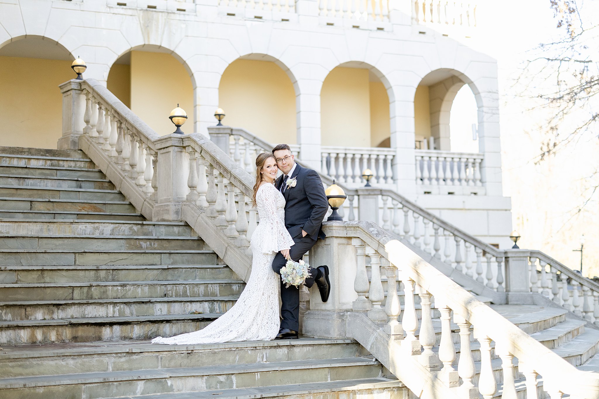 Newlyweds hug while leaning on a large concrete staircase virginia elopement